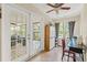 Bright sunroom features tile floors, ceiling fan, and French doors leading to a deck with comfortable seating at 7240 Creek Dr, New Port Richey, FL 34655