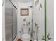 Unique bathroom features a shower, toilet with decorative accents, and painted bamboo wall art at 7506 Moriah Ave, Brooksville, FL 34613