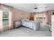 Cozy bedroom with pink walls, soft carpet, and natural light, creating a peaceful retreat for relaxation and rest at 7506 Moriah Ave, Brooksville, FL 34613