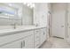 Bathroom with double sinks, white cabinets, a large mirror, and a view of the tiled shower area at 778 Parsons Mooring Ct, Seffner, FL 33584