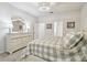 Bedroom with a large dresser, decorative lamps, neutral color scheme, and a cozy bed with patterned bedding at 778 Parsons Mooring Ct, Seffner, FL 33584