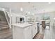 Open kitchen with white cabinetry, stainless steel appliances, and a large center island with pendant lighting at 778 Parsons Mooring Ct, Seffner, FL 33584