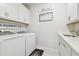 Laundry room with white cabinets, washer, dryer, sink, and decorative wall signs at 778 Parsons Mooring Ct, Seffner, FL 33584