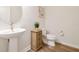 Powder room with a pedestal sink, decorative wood cabinet, modern toilet, and stylish decor at 778 Parsons Mooring Ct, Seffner, FL 33584