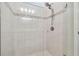 Close-up of a tiled shower featuring a shower head, glass door, and decorative tile accents at 778 Parsons Mooring Ct, Seffner, FL 33584