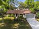 Charming single-story home featuring mature trees, a well-kept lawn, and a two-car garage at 8364 Eldridge Rd, Spring Hill, FL 34608