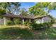 Exterior view of home with mature landscaping, driveway and lawn at 8364 Eldridge Rd, Spring Hill, FL 34608