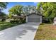 Home featuring a long driveway, lawn, and front landscaping at 8364 Eldridge Rd, Spring Hill, FL 34608