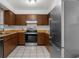 This kitchen features stainless steel appliances, wooden cabinets, light countertops, and tile flooring at 8364 Eldridge Rd, Spring Hill, FL 34608