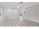 Open concept living room with tile floors, ceiling fan, and a bright view to other parts of the home at 8364 Eldridge Rd, Spring Hill, FL 34608