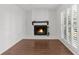 Inviting living room featuring a cozy fireplace, hardwood flooring, and plantation shutters at 8364 Eldridge Rd, Spring Hill, FL 34608