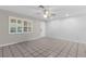 Bright and airy living room with white walls, tile flooring, large window, and ceiling fan at 8364 Eldridge Rd, Spring Hill, FL 34608