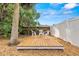 Backyard area features a small deck with chairs, and is mulched with palm tree at 856 Wisconsin Ave, Palm Harbor, FL 34683