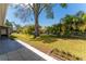 Expansive backyard featuring lush lawn, mature trees, and a charming garden bed, perfect for outdoor enjoyment at 8705 Village Mill Row, Hudson, FL 34667