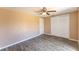 Bedroom featuring a ceiling fan, wood-look tile floor, a closet with sliding doors, and neutral colored walls at 8705 Village Mill Row, Hudson, FL 34667