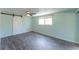 The bedroom with light paint features tile floors, ceiling fan and view to the screened porch at 8705 Village Mill Row, Hudson, FL 34667