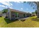 Well-maintained home exterior with neutral siding, neatly landscaped yard, and sunny blue sky at 8705 Village Mill Row, Hudson, FL 34667