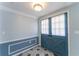 Stylish foyer featuring a blue front door, modern lighting, and decorative wainscoting at 8705 Village Mill Row, Hudson, FL 34667