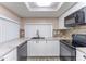 Modern kitchen with white cabinets, granite countertops, stainless steel dishwasher, and black stove at 8705 Village Mill Row, Hudson, FL 34667