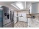 Updated kitchen with stainless steel appliances, granite countertops, and white cabinetry at 8705 Village Mill Row, Hudson, FL 34667