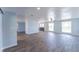 Bright living room featuring wood-look flooring, light blue walls, and ample natural light from large windows at 8705 Village Mill Row, Hudson, FL 34667