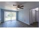 Bright living room with sliding glass doors that lead to a yard, complemented by tile flooring and neutral paint at 8705 Village Mill Row, Hudson, FL 34667