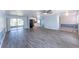 Open-concept living room with wood-look flooring, leading to a kitchen and screened-in patio at 8705 Village Mill Row, Hudson, FL 34667
