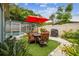 Private backyard featuring a dining area, grill, and lush greenery, perfect for outdoor entertaining and relaxation at 9040 Mark Twain Ln, Port Richey, FL 34668