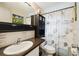 Bathroom featuring a seashell shower curtain and dark brown granite countertops at 9040 Mark Twain Ln, Port Richey, FL 34668