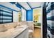 Bright bathroom with blue accent walls and a view into the adjacent bedroom at 9040 Mark Twain Ln, Port Richey, FL 34668