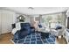 Cozy living room featuring plush seating, a decorative fireplace, and a large window for natural light at 9040 Mark Twain Ln, Port Richey, FL 34668