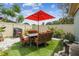 Outdoor patio area featuring an outdoor table, seating, and an umbrella at 9040 Mark Twain Ln, Port Richey, FL 34668
