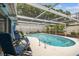 Screened-in pool area with comfortable blue lounge chairs at 9040 Mark Twain Ln, Port Richey, FL 34668