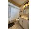 Well-lit bathroom featuring a shower with striped curtain, and white vanity with a framed mirror at 9350 Barrington Ln, Port Richey, FL 34668