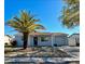 Single-story home with a palm tree in the front yard, attached garage and a well-maintained lawn and inviting entrance at 9350 Barrington Ln, Port Richey, FL 34668