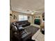 Inviting living room featuring tile floors, a cozy leather sectional, a fan, and a view towards the home's entrance at 9350 Barrington Ln, Port Richey, FL 34668