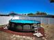 View of the above ground pool with ladder and pump feature in fenced in backyard at 9350 Barrington Ln, Port Richey, FL 34668