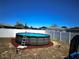 Backyard featuring an above ground pool with a ladder, and surrounded by a white fence at 9350 Barrington Ln, Port Richey, FL 34668