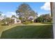 Expansive backyard featuring well-kept grass, mature trees, and views of neighboring homes at 1005 Indigo Run Ct, Spring Hill, FL 34609