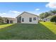 Large backyard with well-maintained lawn and the exterior of the home at 1005 Indigo Run Ct, Spring Hill, FL 34609