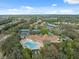 Aerial shot featuring the community center, pool, tennis courts, and lush landscape, illustrating a complete community at 1005 Indigo Run Ct, Spring Hill, FL 34609