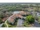 Aerial view showcasing the community pool with a spa and lounge chairs, surrounded by lush greenery and a spacious parking area at 1005 Indigo Run Ct, Spring Hill, FL 34609