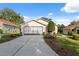 Exterior shot of a well-maintained home with a two-car garage, neat landscaping, and a concrete driveway at 1005 Indigo Run Ct, Spring Hill, FL 34609