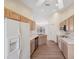 This bright kitchen features wood cabinets, white appliances, and wood flooring at 1005 Indigo Run Ct, Spring Hill, FL 34609