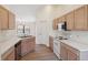 Well-lit kitchen featuring white countertops, wood cabinetry and stainless steel dishwasher at 1005 Indigo Run Ct, Spring Hill, FL 34609