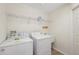 Convenient laundry room with washer, dryer, utility sink, and shelving for storage at 1005 Indigo Run Ct, Spring Hill, FL 34609