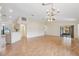 Open-concept living room with wood floors, a chandelier, and access to the kitchen and a screened in porch at 1005 Indigo Run Ct, Spring Hill, FL 34609