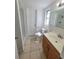 Bright bathroom with tile flooring, wood vanity, and shower at 10921 Stamford Dr, Port Richey, FL 34668
