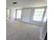 Spacious living room featuring neutral-colored walls, carpet flooring and natural light at 10921 Stamford Dr, Port Richey, FL 34668