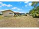 A spacious backyard features a screened-in pool, lush landscaping, and sunny skies at 11256 Holbrook St, Spring Hill, FL 34609